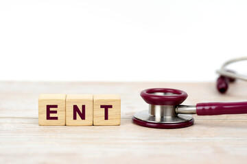 Word (Ear Nose and Throat) ENT on wooden blocks and stethoscope on the wooden table with white...