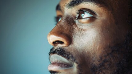 Obraz premium portrait of a man's face, his eyes gazing off into the distance, set against a soft