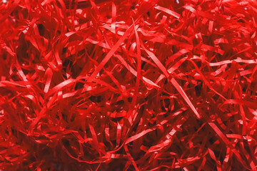 Decorative red confetti of red color cut into a strip, eco for gift wrapping