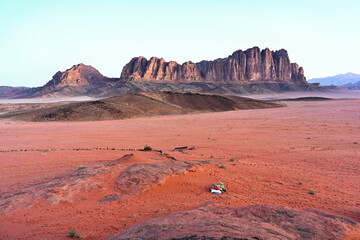 Ein Panorama des markanten Al Qattar Massiv in der Wüste des Wadi Rum in Jordanien bei strahlen...