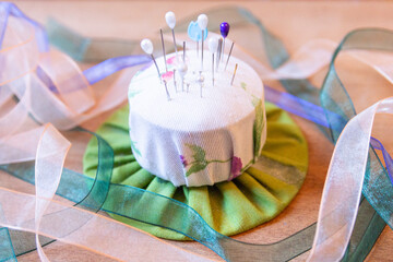 Colorful pin cushion with ribbons in a sewing workshop
