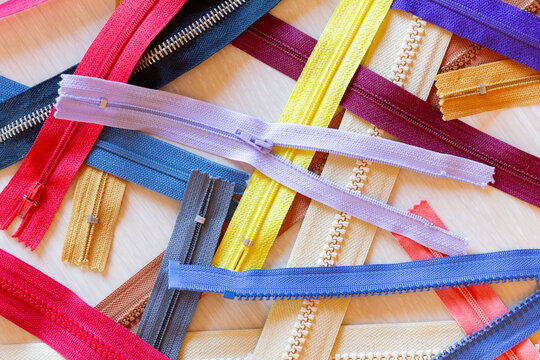 Colorful Assortment of Zippers on Wooden Table