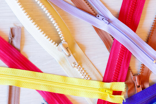 Colorful zippers on a wooden surface for craft projects