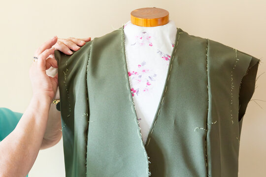 Tailor adjusting a garment on a mannequin during fitting