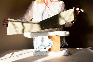 Tailor Examining Fabric in Sunlit Sewing Studio
