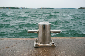 View of the sea waves and bollard at sea