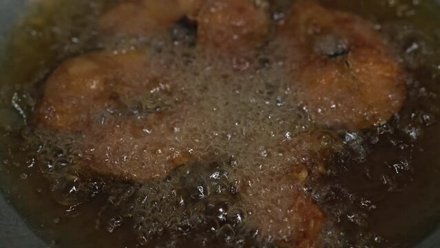 Fried Fish In Pan.Fish meat placed into pot with hot oil. Cooking fish in hot oil pan. Cooking Fish and chips dish.