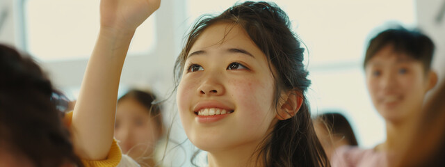 Lively high school classmates, their expressions animated as they participate in a lesson, a smiling, confident Asian girl raising a hand  to answer the teacher's query..