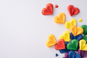 Colorful paper hearts in rainbow colors arranged on a white background, symbolizing love,...