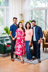 Reunion of Indian asian young friends or couple posing for a group photo inside living room