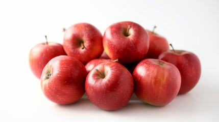 Group of fresh red apples with glossy skin piled together on a clean white background