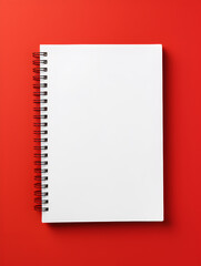 Blank spiral bound notebook with empty page on red background 