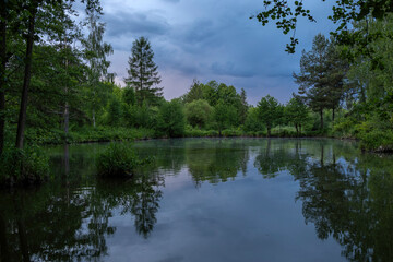 Pond under dramatic skies before nightfall