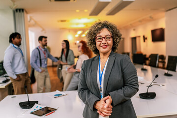 Portrait of older African American businesswoman standing in front of her colleagues.