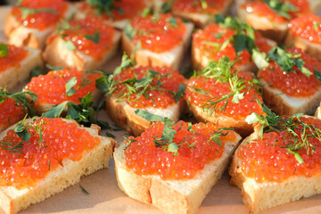 red salmon caviar on white bread sprinkled with green parsley and dill