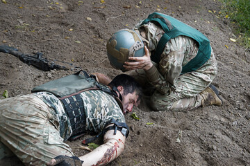 The friend cries at wounded soldier