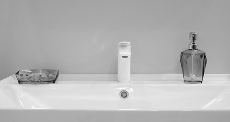 A sink with a soap dispenser and a toothbrush holder
