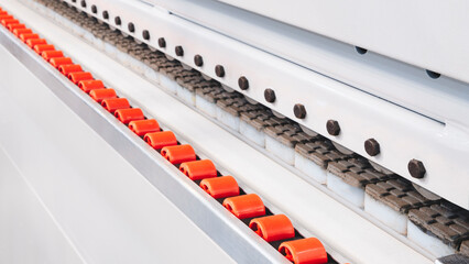A conveyor belt with red and white balls on it