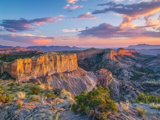 A series of mesas rising from the desert floor, their flat tops and steep sides glowing in the warm light of sunset. The expansive sky and rugged terrain create a dramatic 