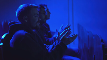 Men applaud performance in theater. Media. Men sit in one row and clap for performance. Theatrical...