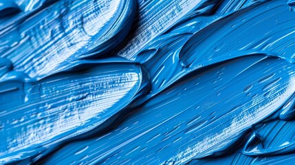  A tight shot of blue paint with numerous droplets resembling water cascading from its top surface