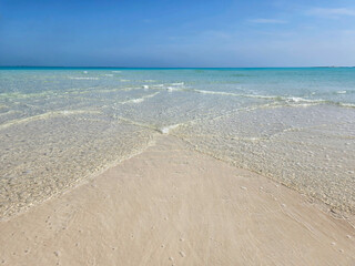 Sandbar and clear shallow water of Treasure Cay, Abaco, Bahamas on sunny summer day.