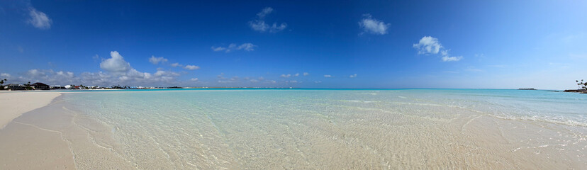 Panorama of sandbar and clear shallow water of Treasure Cay, Abaco, Bahamas on sunny summer day.