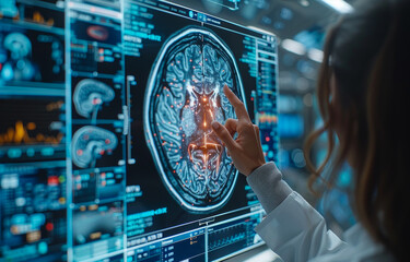 A woman is pointing at a brain scan on a computer monitor. The image is a close up of a brain with a red dot in the middle. The woman is wearing a white lab coat - Powered by Adobe