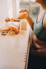 Binge eating disorder concept with woman eating fast food burger, fired chicken , donuts and...