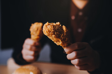 close up focus woman hand hold fried chicken for eat,girl with fast food concept