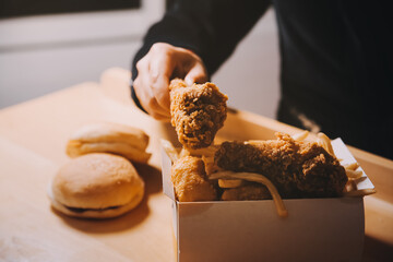 close up focus woman hand hold fried chicken for eat,girl with fast food concept