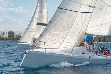 Fototapeta premium Close-up of competitive sailing yachts with billowing sails in a regatta on the mediterranean sea