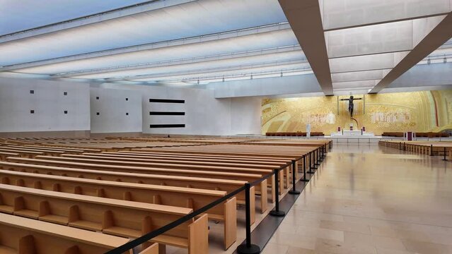 Interior of the modern Minor Basilica of Most Holy Trinity at Fatima, Portugal. View over the altar, aisles and pews. Fatima is a major Marian Shrine for pilgrims