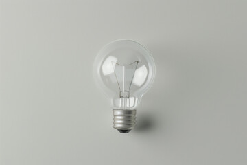 Single incandescent light bulb is centered against a clean, neutral background, symbolizing ideas, innovation, and simplicity in this minimalist composition