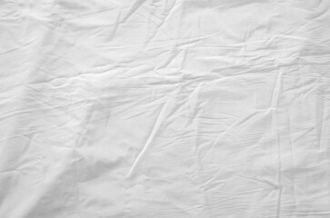 Top view of wrinkles on an unmade bed sheet after waking up in the morning.