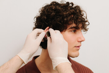 Ent doctor examine ear of patient with ear funnel. Checking the outer ear canal and eardrum....