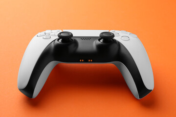 One wireless game controller on orange background © New Africa