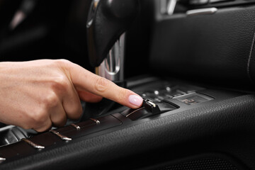 Woman using gear stick while driving her car, closeup