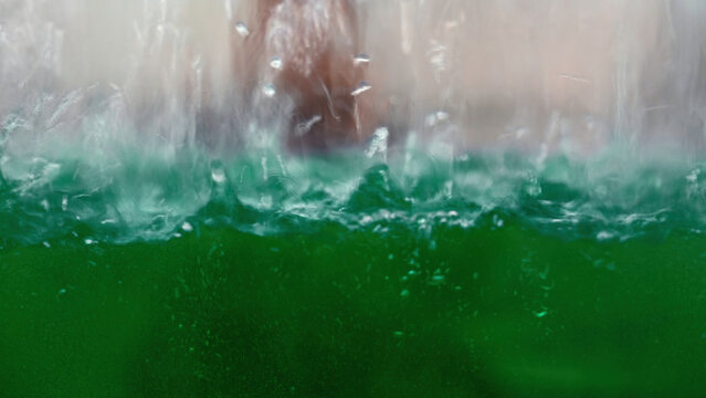 industrial background with a transparent reservoir being filled with liquid. Media. Water drops falling down and making ripples.
