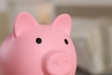 Pink piggy bank on blurred background, closeup
