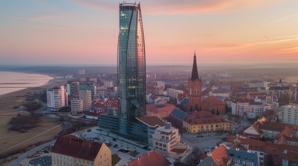 Obraz premium Sleek glass tower shining amidst the charming historic architecture of the old town