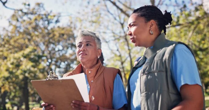 Women, volunteer and teamwork with clipboard in park for community service, support and planning. NGO, charity and mature manager with discussion in nature for brainstorming, idea and sustainability
