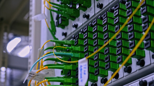 Close up of optical fiber switchboard hub in a server room. Stock footage. Concept of AI, internet, and modern technologies.