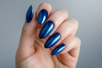Someone is holding a blue manicure with a shiny blue nail