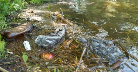 Garbage lies on lake shore, pollution of environment. Plastic must be recycled