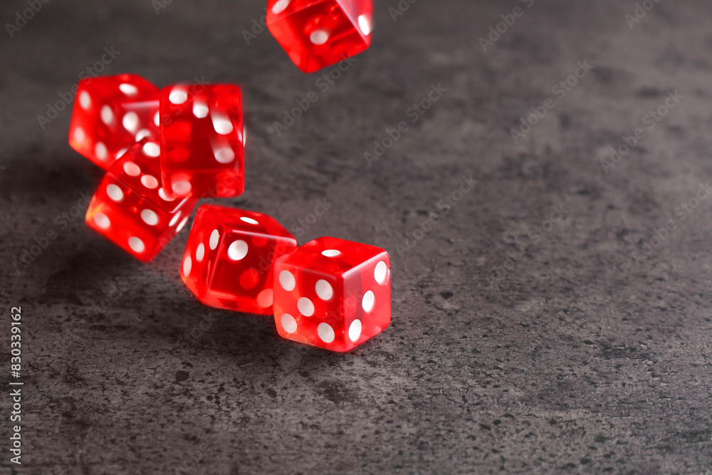 Poster Many red game dices falling on grey textured table. Space for text