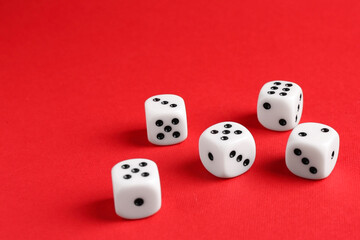 Many white game dices on red background