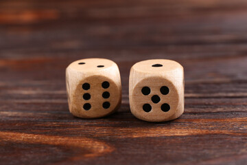 Two game dices on wooden table, closeup