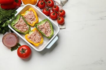 Raw stuffed peppers and ingredients on white table, flat lay. Space for text