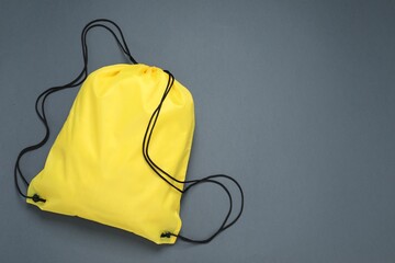 Yellow drawstring bag on grey background, top view. Space for text